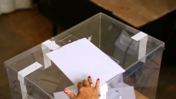 女性が封筒の投票を透明なプラスチック製の投票箱に投票します 人間の手投票 — ストック動画