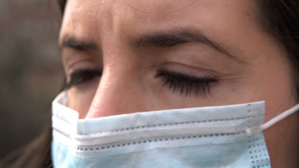 科罗纳韦勒斯病 Covid 爆发期间 年轻女性戴着保护性外科口罩 近景肖像画与单一使用蓝色保护面具在脸上 看着相机 — 图库视频影像