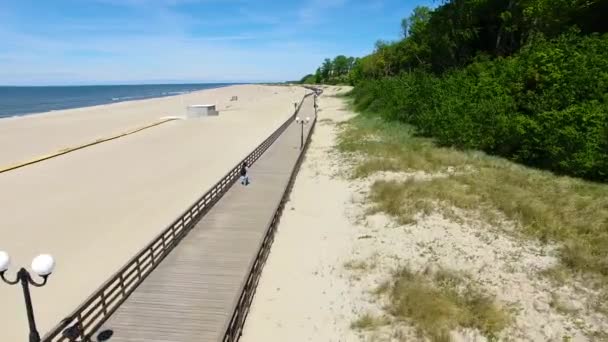 Largo paseo marítimo de madera en la playa — Vídeos de Stock