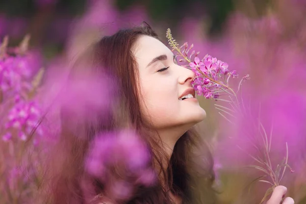 Mujer joven en flores rosadas — Foto de Stock