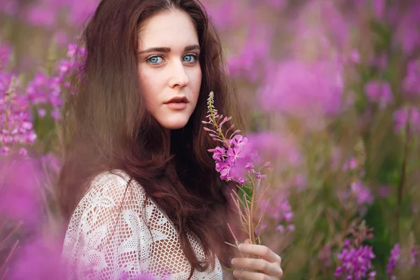 Mujer joven en flores rosadas — Foto de Stock