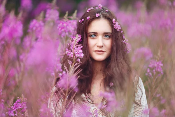 Ung kvinna i rosa blommor — Stockfoto