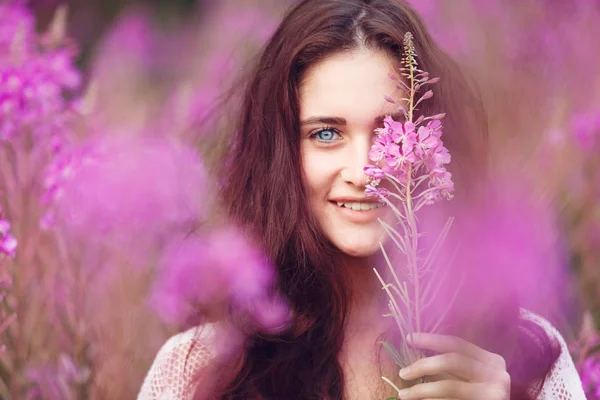 Mujer joven en flores rosadas — Foto de Stock