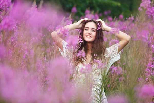 Mujer joven en flores rosadas — Foto de Stock