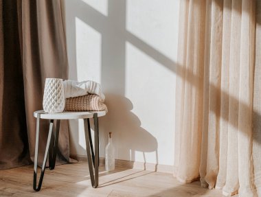 Gün ışığı apartmanında rahat bir hayat. Beyaz masalı vazo ve süveterler.