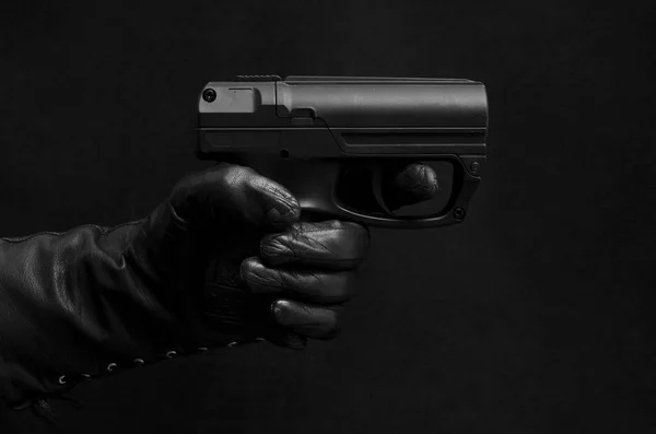 Schwarze Pistole, schwarze Lederhandschuhe, schwarzer Hintergrund — Stockfoto