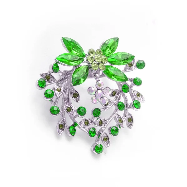 Silberne Blumenbrosche mit hellgrünen Diamanten auf weißem Grund — Stockfoto