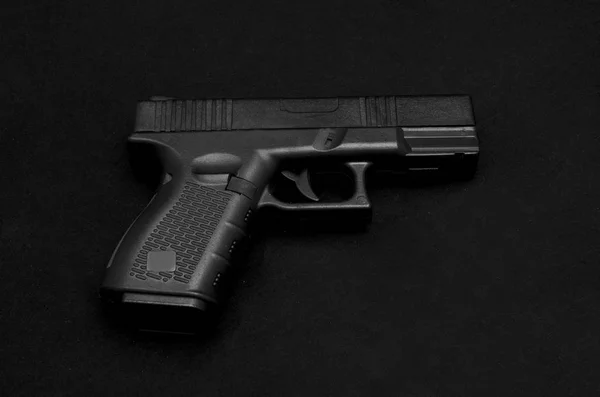 Pistola preta no fundo preto — Fotografia de Stock