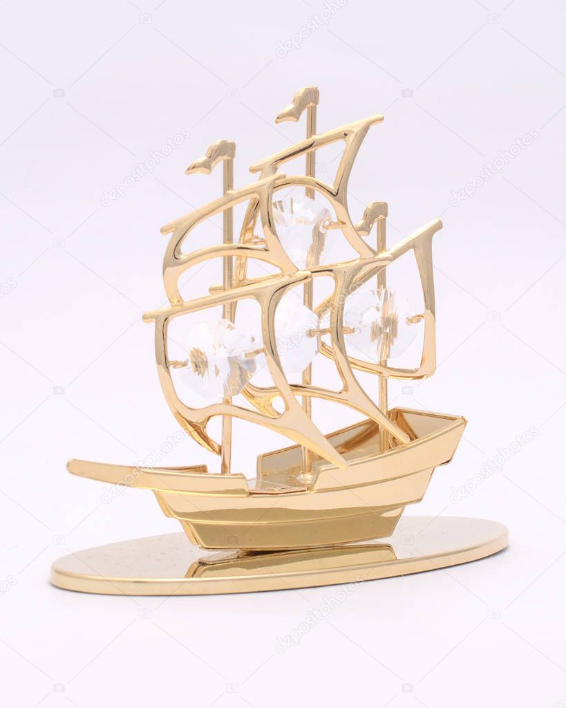golden ship figurine with diamonds isolated on white