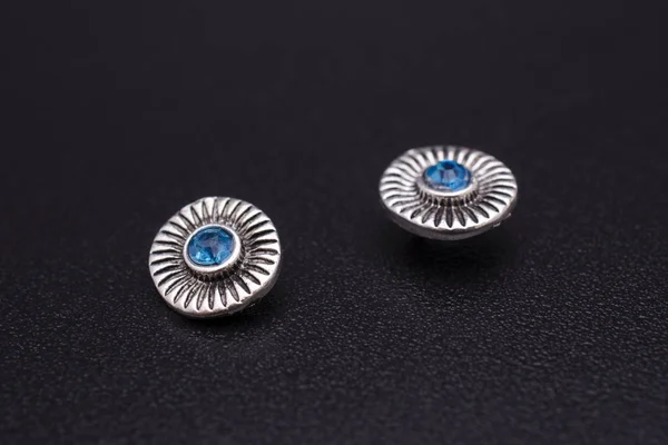 silver stud earrings with blue stone isolated on black