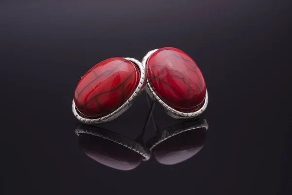 Pendientes de plata con piedras rojas aisladas en negro —  Fotos de Stock