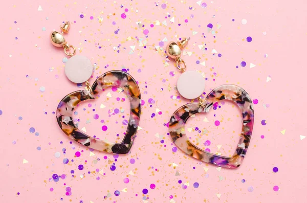 Earrings hearts in the style of the eighties, in spangles isolated on pink background — Stock Photo, Image