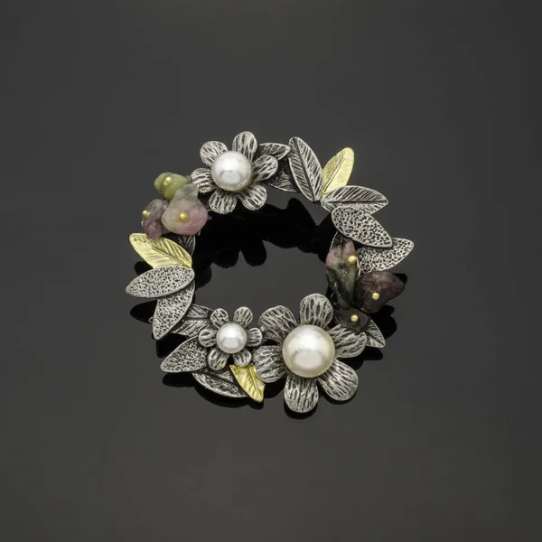 Broche ronde avec fleurs et perles isolées sur fond noir — Photo