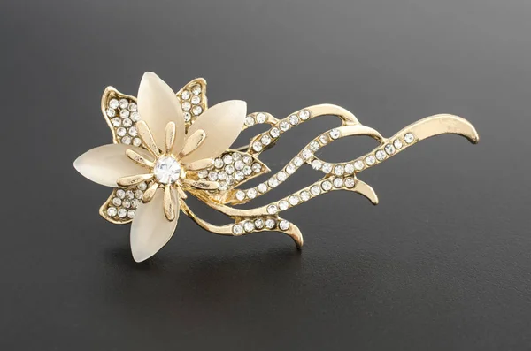 Gold brooch flower with gems and moon stone isolated on black — Stock Photo, Image