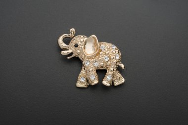 gold elephant brooch isolated on black clipart