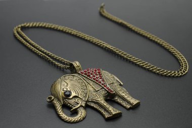 gold pendant elephant isolated on black clipart