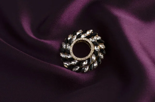 Broche redondo con gemas aisladas sobre seda — Foto de Stock