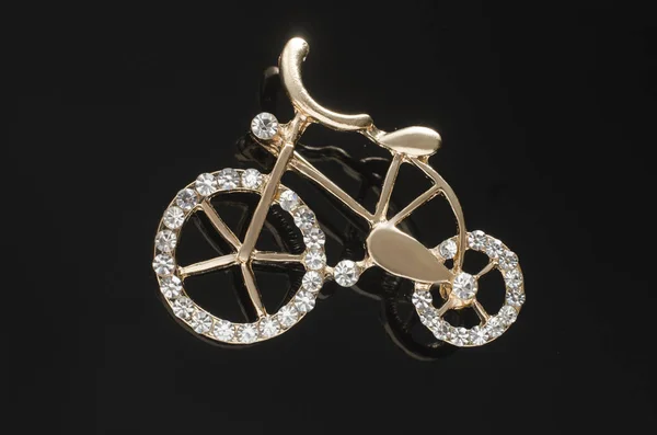 Золотая брошь велосипед с драгоценными камнями изолированы на черном фоне — стоковое фото