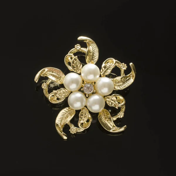 Broche fleur d'or avec perle isolée sur noir — Photo