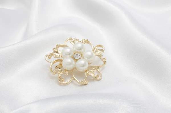 Broche fleur d'or avec perle sur fond de soie — Photo