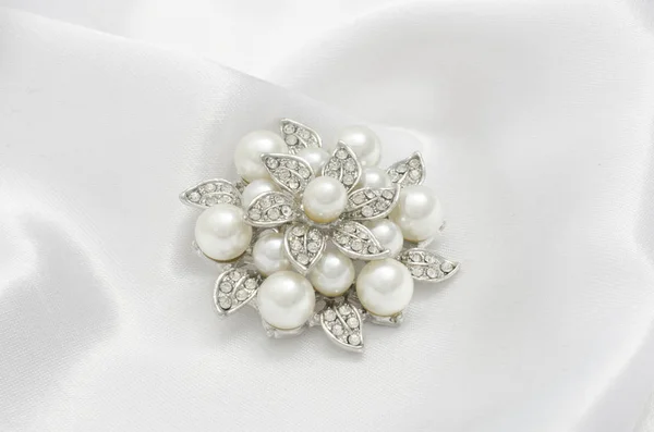 Silver brooch flower with pearl on silk — Stock Photo, Image