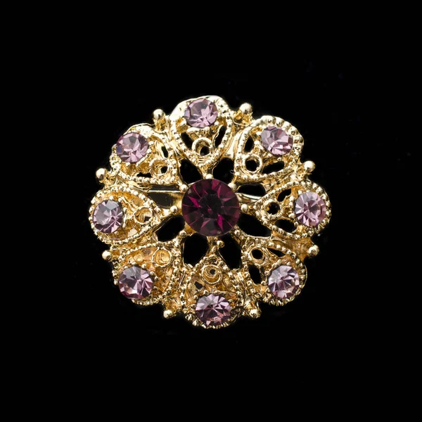 Gold round brooch with purple diamonds isolated on black — Stock Photo, Image
