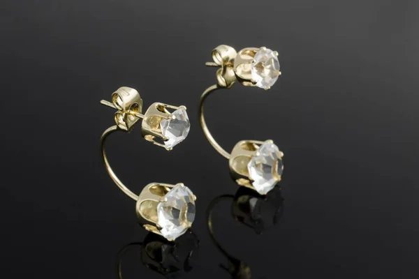 Золоті сережки з діамантами ізольовані на чорному — стокове фото