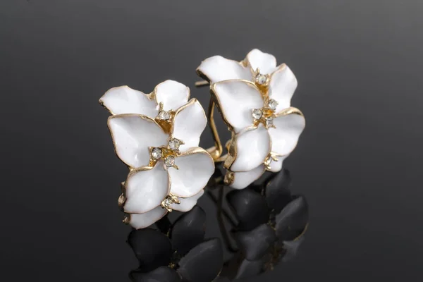 Gouden oorbellen met bloem geïsoleerd op zwart — Stockfoto
