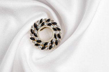 İpek üzerinde izole taşlar ile yuvarlak broş