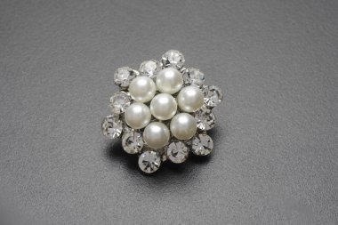 inci ve siyah arka plan üzerinde mücevher altın yuvarlak broş