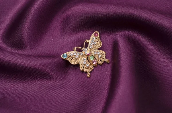 Brosche goldener Schmetterling mit Diamanten auf Seidenstoff — Stockfoto