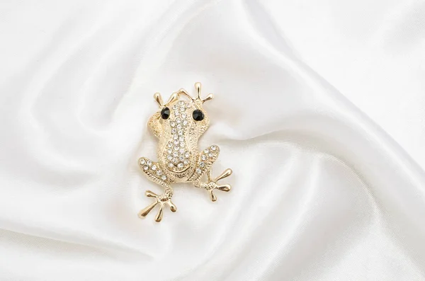 Золотая брошь с бриллиантами на шелковой ткани — стоковое фото