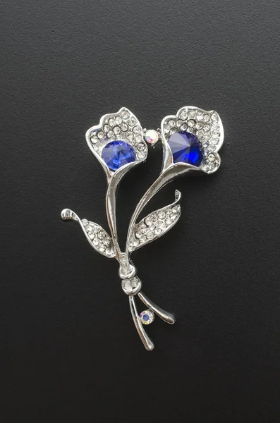 Flor de broche de plata con piedra azul aislada en negro — Foto de Stock