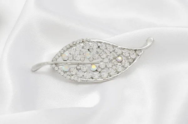 Folha de broche de prata com diamantes isolados na seda — Fotografia de Stock