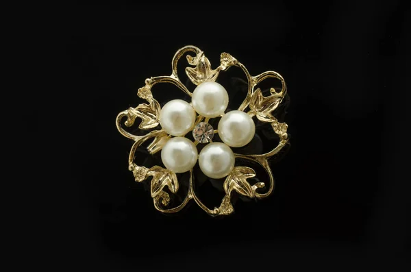 Spilla fiore in oro con perla isolata su nero — Foto Stock