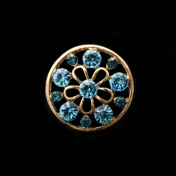 Gold round brooch with blue diamonds isolated on black — Stock Photo, Image