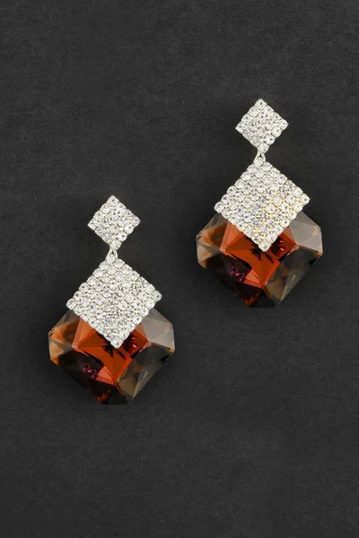 Boucles d'oreilles en or avec de grandes pierres rouges isolées sur noir — Photo