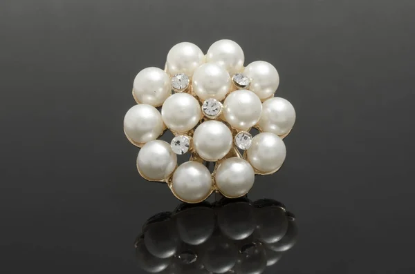 Broche ronde en or avec perles sur fond noir — Photo