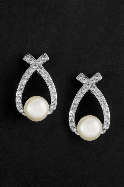 Earrings with pearls and diamonds on black background