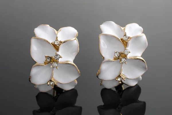 Goldene Ohrringe mit Blume isoliert auf schwarz — Stockfoto