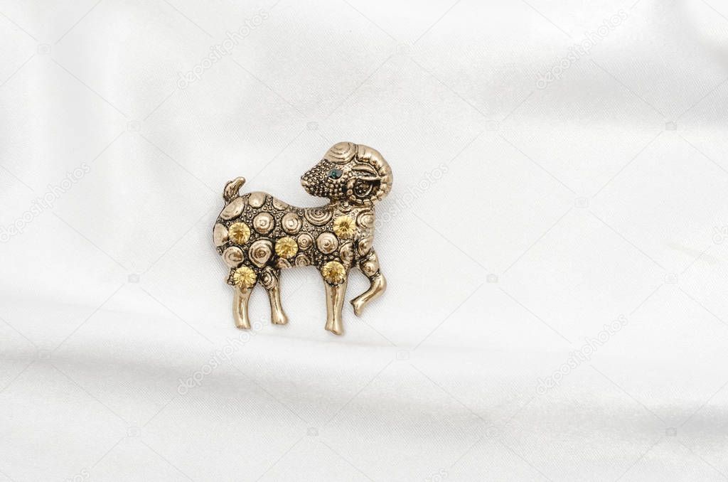 Copper brooch with diamonds aries on silk fabric