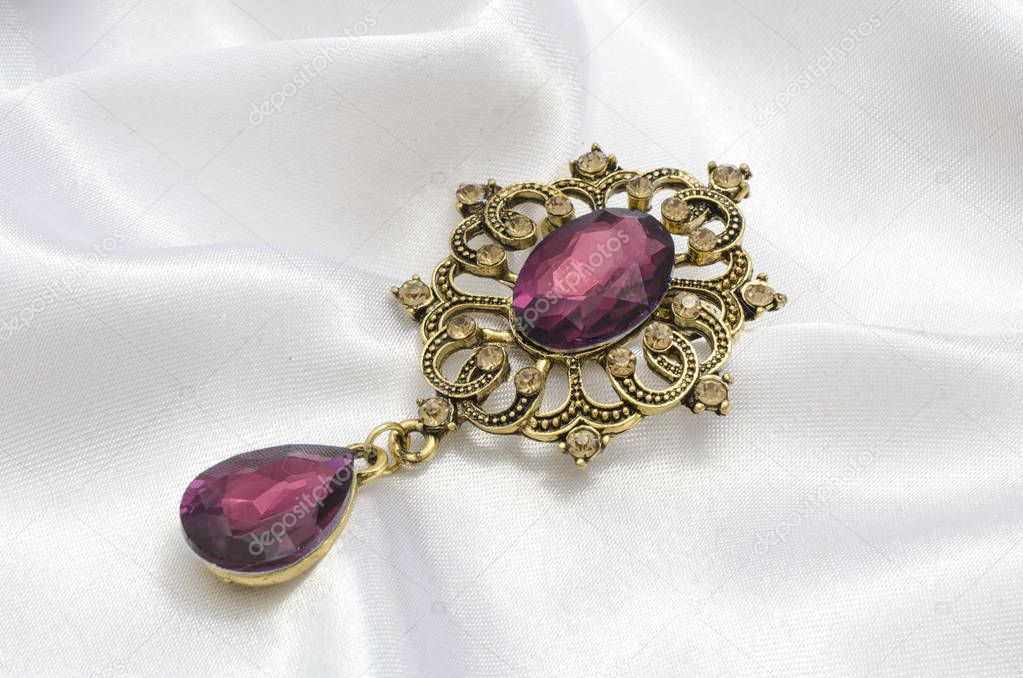 golden vintage brooch with crimson stone on silk