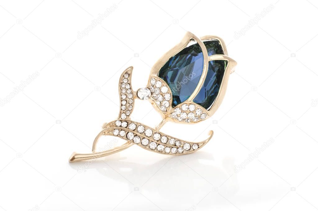 gold brooch rose bud with blue stone and diamonds isolated on white