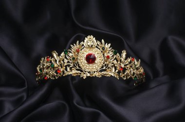 golden crown with rubies  on a black silk clipart
