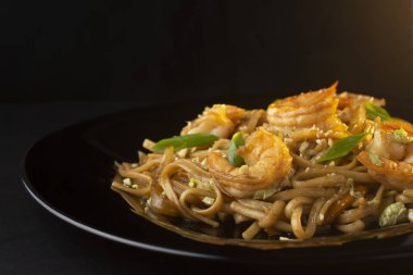 Erişte, salça, karides ve siyah tabakta otlar, makro