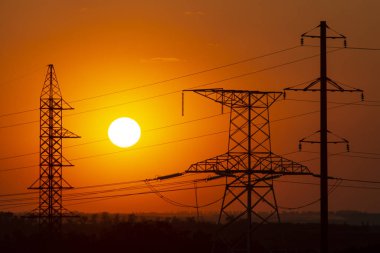 Elektrik hatlarının arka planında gün batımı