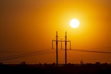 Elektrik hatlarının arka planında gün batımı