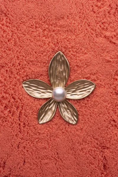 Gold brooch flower with a pearl on the pink sand — ストック写真