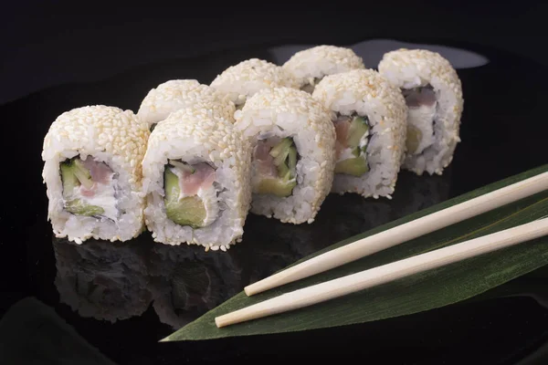 Rotoli di sushi giapponese con crema di formaggio con salmone e cetriolo in sesamo — Foto Stock