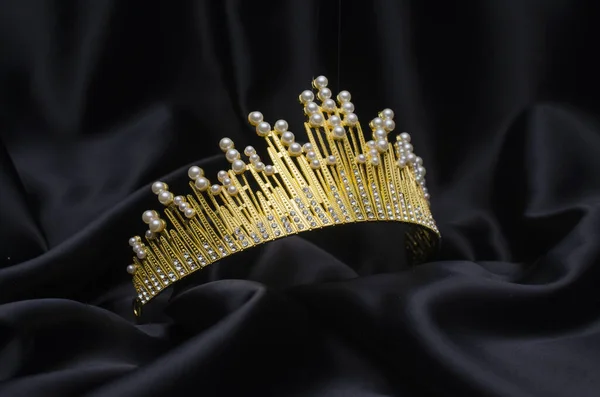Zlatá koruna s perlami a diamanty izolovanými na černém hedvábí — Stock fotografie